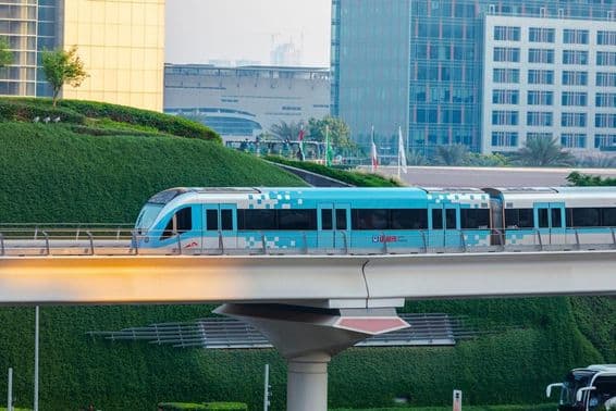 Driverless metro train moving in Dubai city on a sunny day.