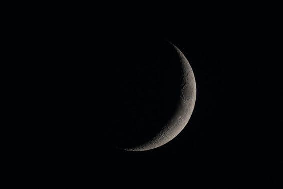 Detailed new moon in the dark sky.