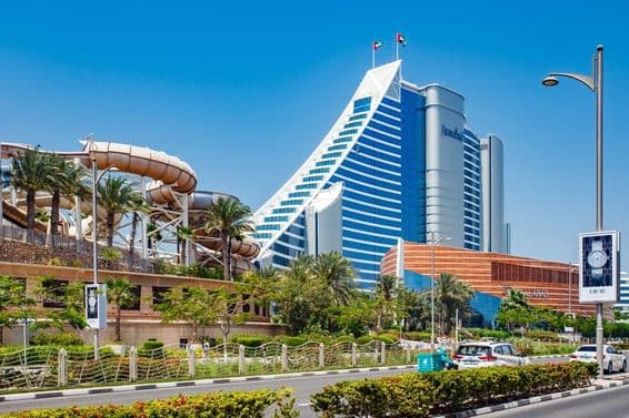 Jumeirah Beach Hotel, eastern part on a clear day, cars on the road, Wild Wadi Waterpark Dubai.