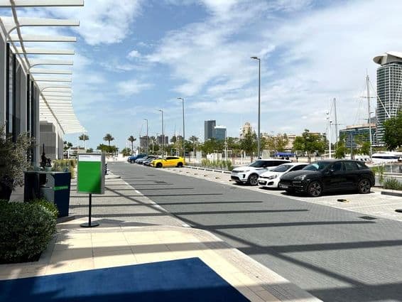 Dubai parking lot with city skyline in the background on a summer day.