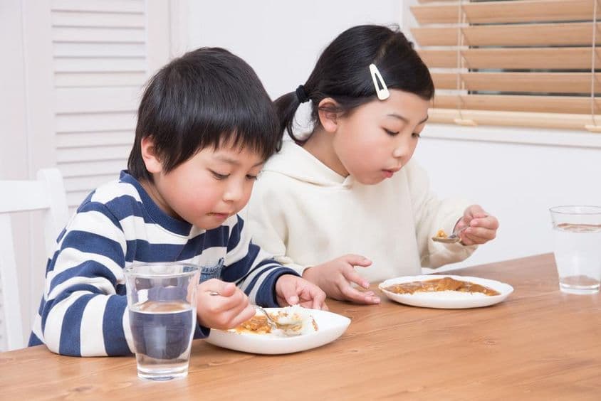 Child eats curry rice at home.