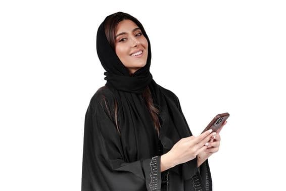 Emirati businesswoman in Arab abaya working on mobile phone.