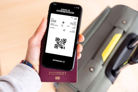 A passport and a digital boarding pass to Rome Fiumicino on a smartphone from Dubai.