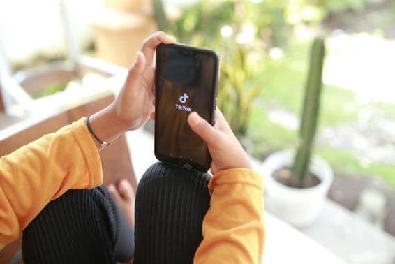 A child watching TikTok media content on a cellphone.