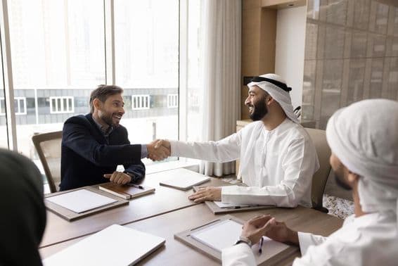 Multinational business partners concluding a successful negotiation with a handshake.