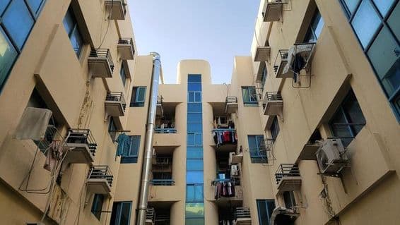 Dubai affordable housing building balcony with air conditioning and laundry.