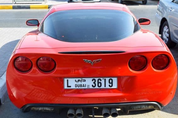 Red Chevrolet Corvette with Dubai license plate.