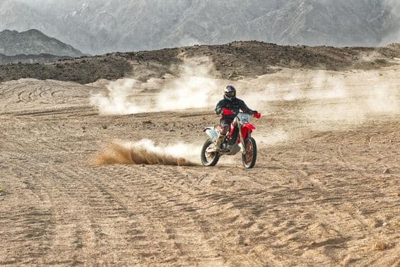 Motorcyclist wearing a helmet riding in the desert