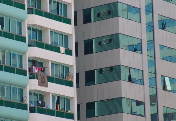 A modern skyscraper in Abu Dhabi with some balconies with carpets.