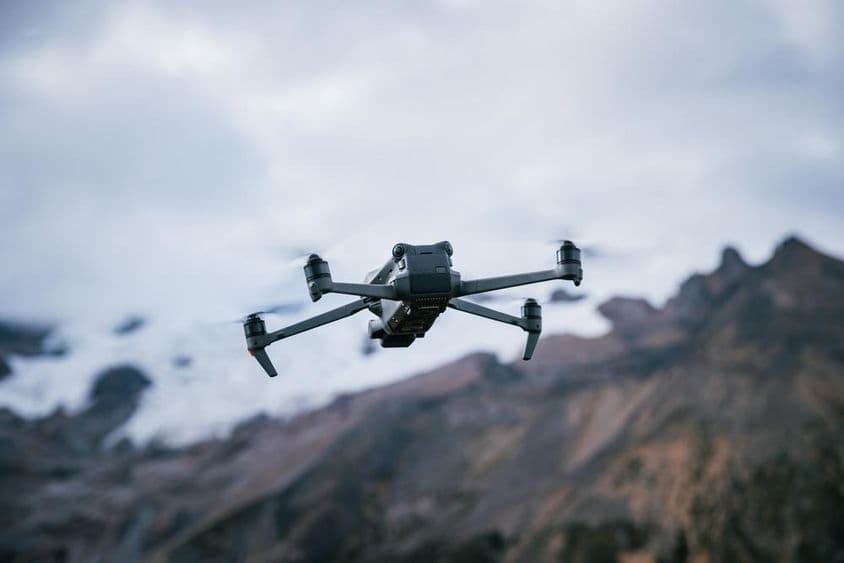 Drone flying over a high-altitude mountain top.