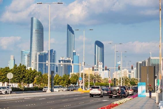 Abu Dhabi, modern skyscrapers tower in the background of the busy Corniche Road.
