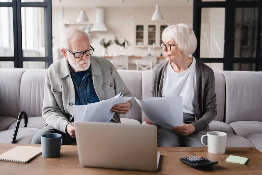 Elderly couple, wife and husband, counting funds, savings.