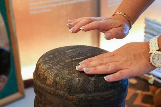 Dubai, United Arab Emirates, African ethnically woman playing on a percussion drum.