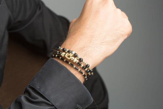 Gold male bracelet on wrist.