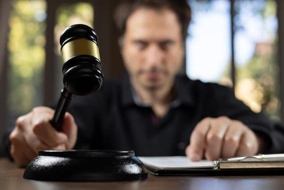 A judge holding a gavel signaling the end of a trial.