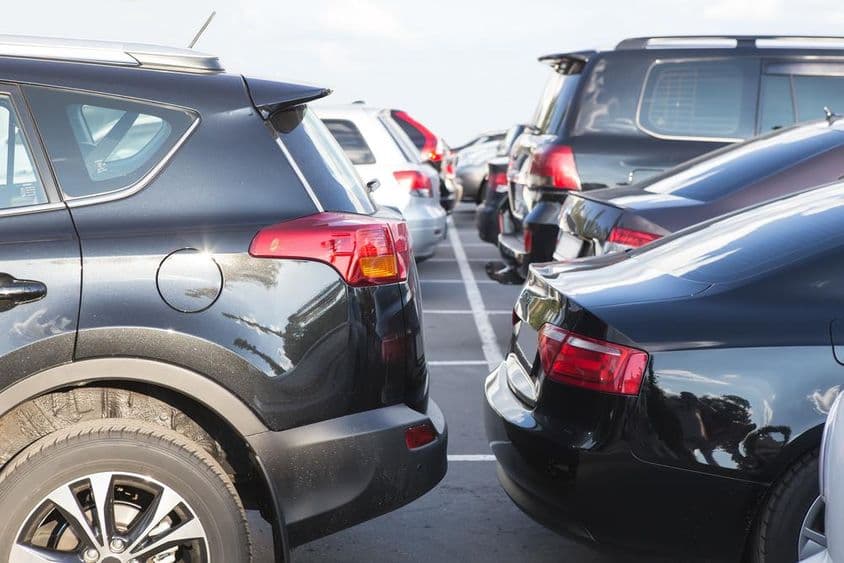 Cars lined up in an outdoor parking lot.