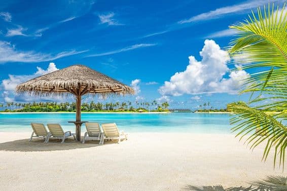 Maldivian sandy beach with umbrella and deck chair.