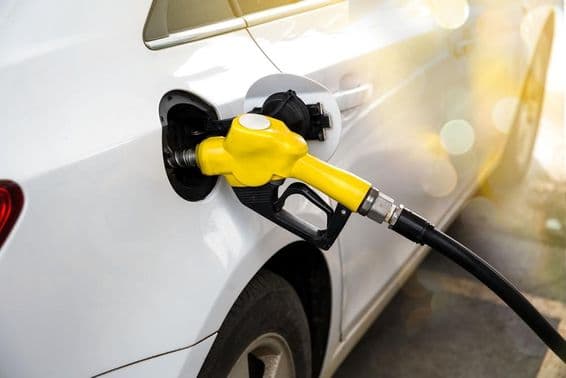 A white car refueling at a Dubai petrol station.
