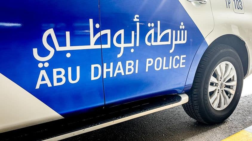 Police car in Abu Dhabi with English and Arabic lettering.