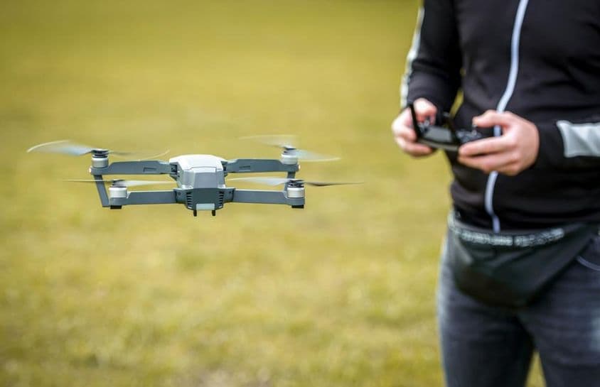 A man controlling a drone with a remote control.