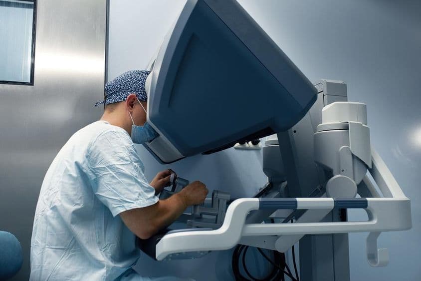 A medical robot is remotely operated by a doctor through a monitor.