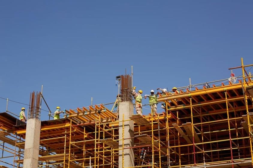 Abu Dhabi, construction workers building skyscrapers.