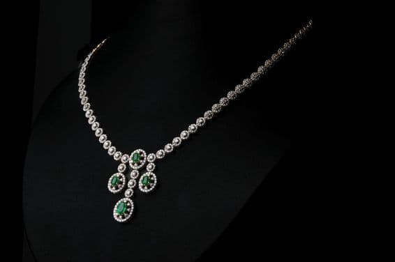 Diamond necklace with green emerald gemstone.