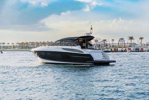 A luxury yacht sails in Dubai near the harbor.