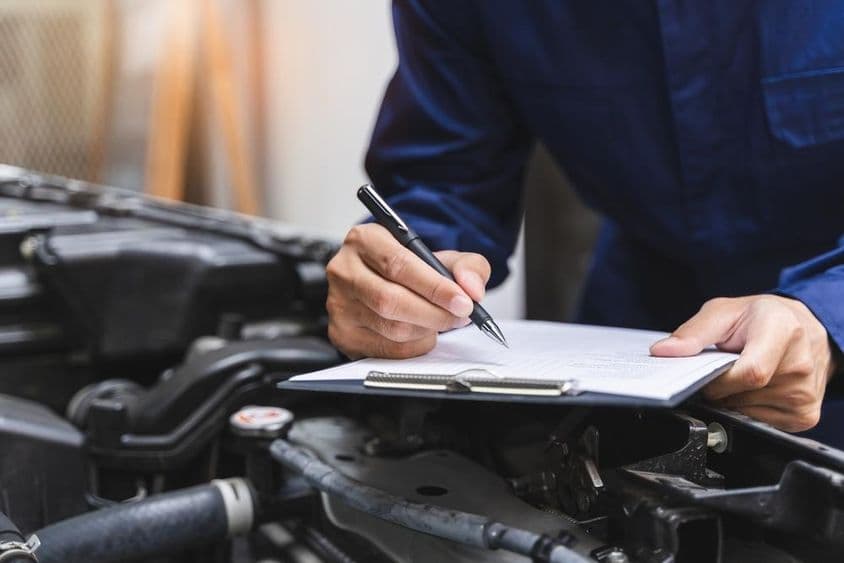 Mechanic writing a task checklist.