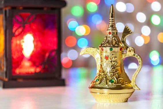 Arab coffee pot and lamp with colorful, blurred lights in the background.