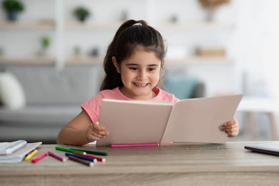 Middle Eastern child studying while sitting at a desk at home.