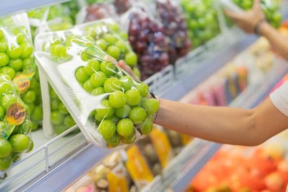 Shelves filled with various fruits, including red grapes and other packaged goods.
