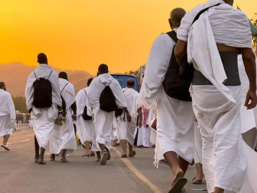 Many Hajj pilgrims walking on the plains of Arafat.