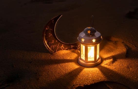 Lantern and crescent moon on sand, Islamic New Year.