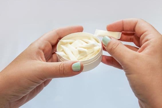 Snus pouches, nicotine patches in hands.