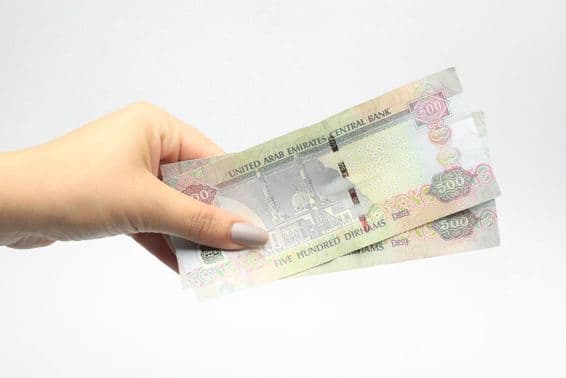 500 AED currency in a woman's hand.
