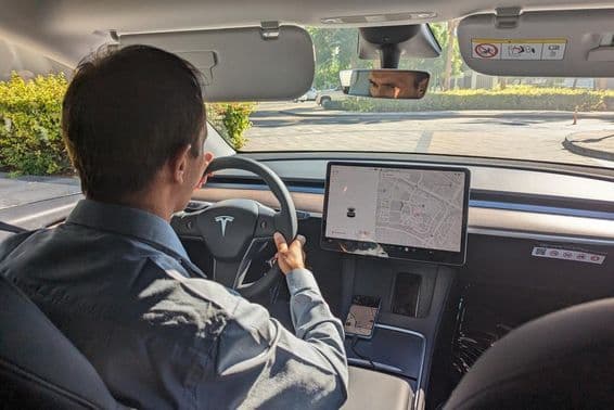 Dubai driver driving a Tesla car on a city road.