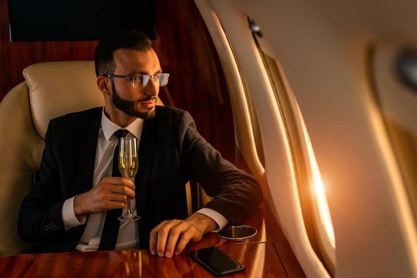 Businessman in an elegant suit, flying on an exclusive private jet.