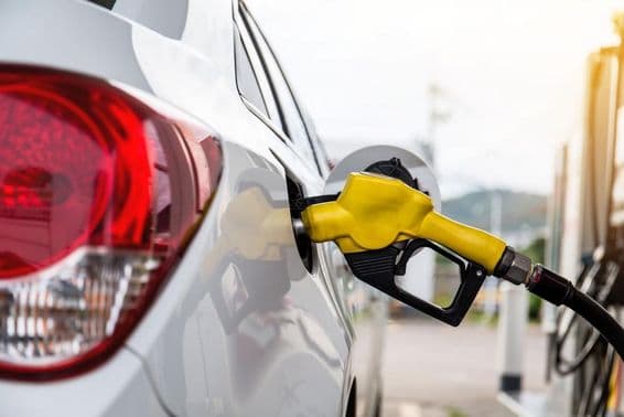 Dubai man pumping gasoline into a car at a gas station.