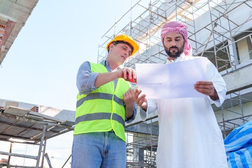 Arab businessman examining a civil engineering blueprint.