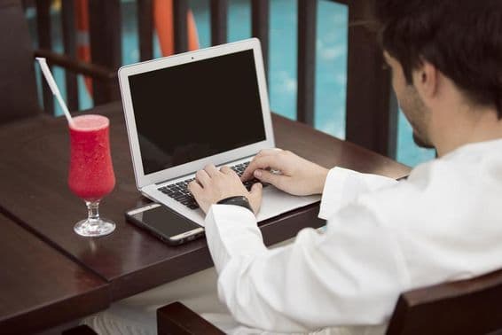 Arab young businessman working with a laptop in a café.