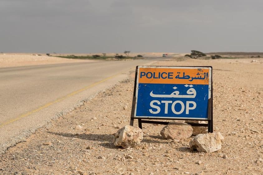 Police stop sign on a desert road.