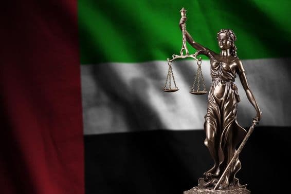 The flag of the United Arab Emirates with a statue of Lady Justice.