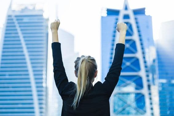 Businesswoman celebrating success with a view of downtown Dubai.