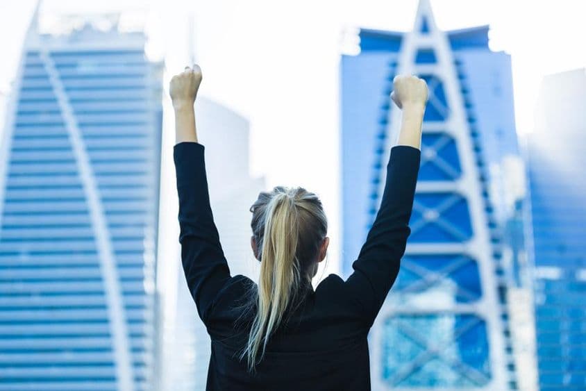 Businesswoman celebrating success with a view of downtown Dubai.