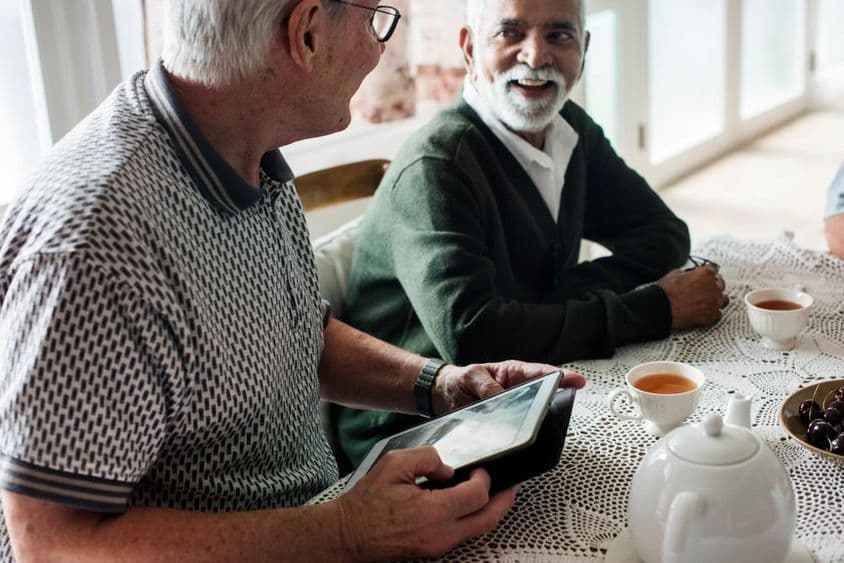 Older friends looking at a tablet together.