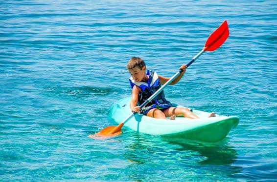 Boy with life buoy during kayaking lessons on summer vacation.