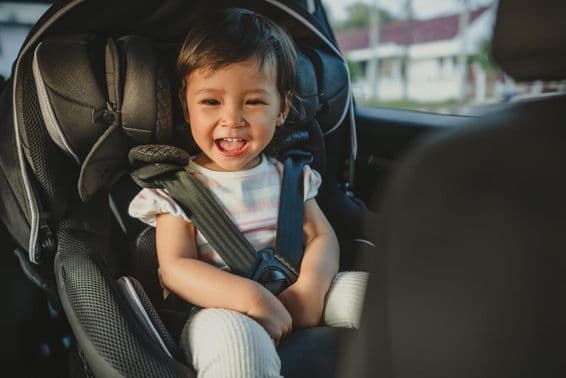 Happy child sitting in a car seat.