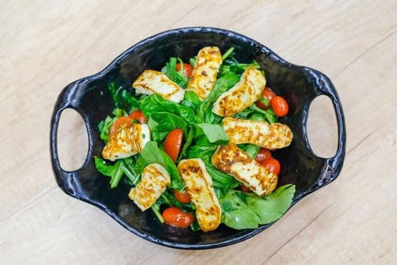 Cheese salad with arugula leaves and cherry tomatoes.