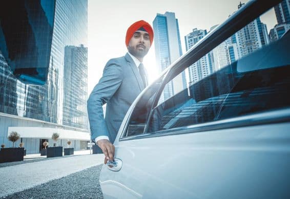 Indian businessman with company car in Dubai.